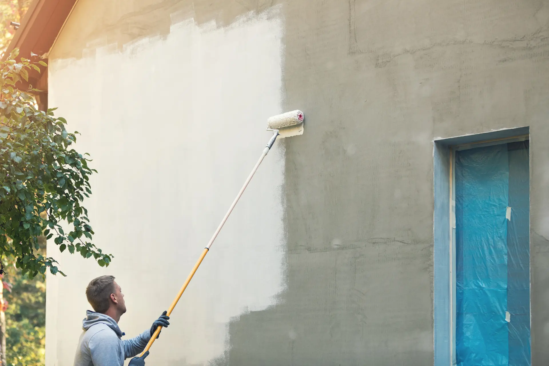 Pintor trabajando en una fachada en Beniorm